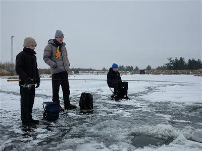 De andre lystfiskere ved søen havde også held med isfiskeriet. Her har et par unge mænd fanget en fin regnbueørred på omkring 3 kilo igennem isen. Far holder opsyn. :)