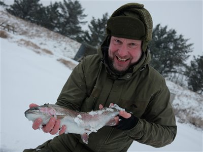 Pausefiskeren med hans allerførste regnbueørred fanget ved isfiskeri.